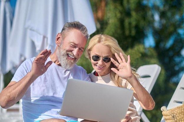 senior couple with laptop on holiday
